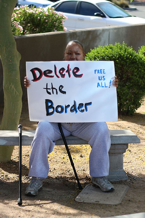 04022014 - Kiri Seawright (cq), 48, of Phoenix, holds a sign at a protest outside the Phoenix ICE facility to raise awareness about deportation. Photo by Alec Damiano / JMC 351