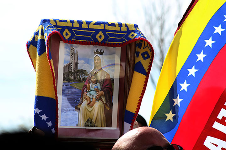 02222014 - Protestors hold up a Venezuelan flag and an image of the Virgin of Coromoto, Venezuela's patron saint. Photo by Alec Damiano / JMC 351