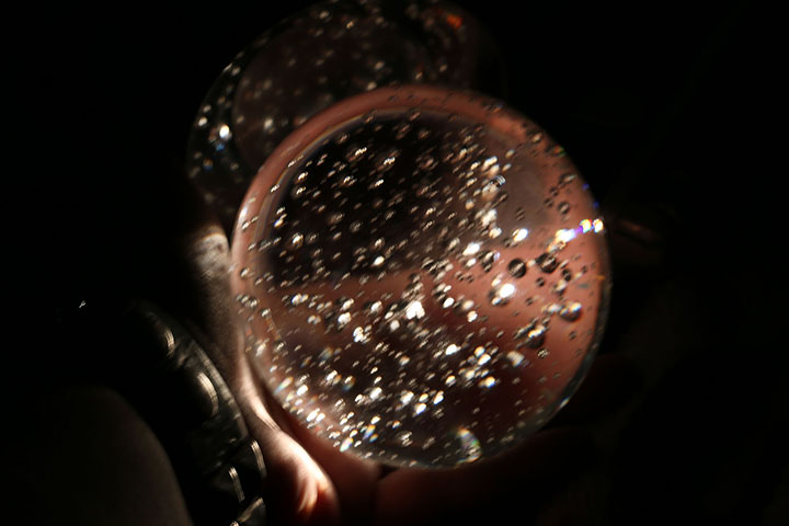 03162014 - A light is shining through a crystal ball as a mirror is shining behind it. The ball is being held in my hand. Photo by Alec Damiano / JMC 351